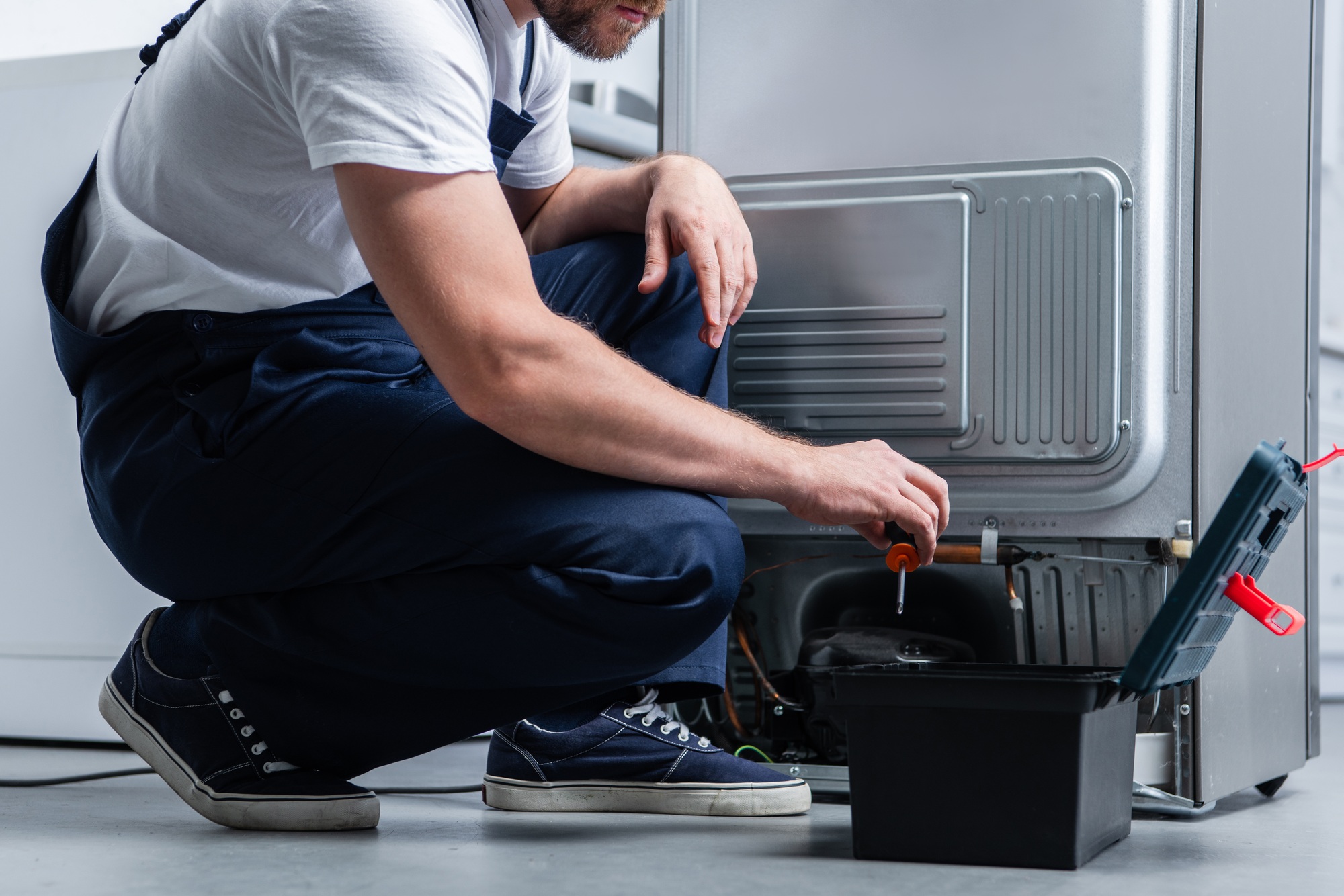 cropped shot of craftsman in working overall near taking screwdriver from toolbox broken